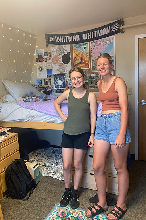 Pan Deines and their roommate smiling in their room.